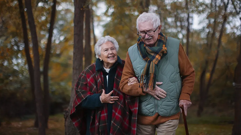 Eldre dame og eldre mann p? tur i skogen